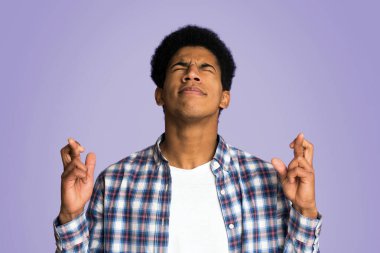 Adam parmakları geçti ve gözleri pembe arka plan karşı kapalı dua