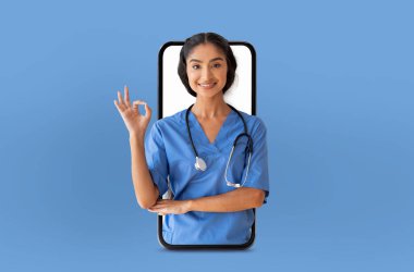 Hintli hemşire elini telefon ekranında gezdirirken görülüyor. Muhtemelen talimat veriyor, bir hastayla iletişim kuruyor ya da tıbbi kayıtlara erişiyor..