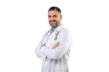 Kendine güvenen bir doktor kollarını kavuşturmuş beyaz önlük ve steteskop takmış profesyonel bir stüdyo ortamında sıcak bir şekilde gülümsüyor. Beyaz arkaplan