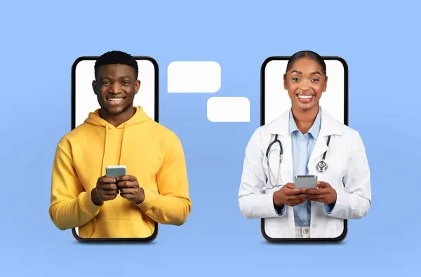 stock image A young black man wearing a yellow hoodie uses his smartphone for an online consultation with a lady doctor. They appear on separate screens, engaged in a remote medical conversation