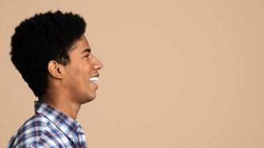 Mutlu gülümseyen Afrikalı adam profil portre. Siyah adam bir kenara fotokopi alanı bakıyor