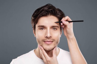 Plastik cerrahi kavramı. Cerrah gri arka plan üzerinde erkek yüzü üzerinde işaretler çizim, panorama