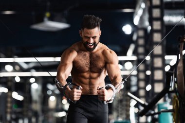 Spor salonunda blok egzersizi yapan genç sporcu trisepsleri, boş alan.