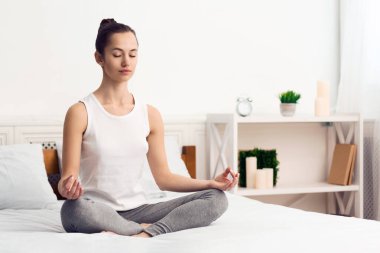 Kadın meditasyon ve sabah yoga pratik, yatakta oturan, kopya alanı