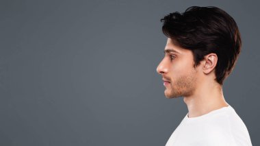Genç yakışıklı beyaz adamın profil portresi, boş alana sahip gri stüdyo arka plan