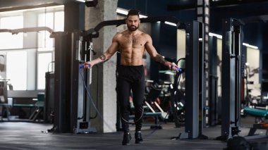 En iyi kardiyo egzersiz. Spor salonu iç ip atlama ile mükemmel vücut eğitimi ile sportif kas adam, boş alan