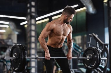 Güçlü halterci spor salonunda ağır halter ile çalışma, boş alan