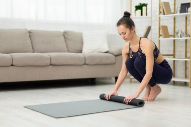 Yoga yaptıktan sonra Rolling Mat. Slim Woman Evde Fitness Ekipmanları Toplama