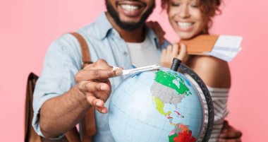 Bir maceraya gitmek. Mutlu çift yolculuk, pembe bir arka plan üzerinde rota seçimi için hazırlanıyor