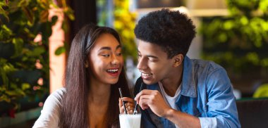 Afro-Amerikalı erkek ve kız bir masada oturmuş milkshake içiyorlar. İçkilerini yudumlarken sohbet ediyorlar, randevularına çıkıyorlar.