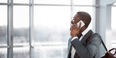 Seyahat eden iş adamı telefon görüşmesi yapıyor, havaalanına varıyor ve kalkışı bekliyor.