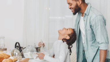 Yardım et, baba. Sevimli siyah kız kurabiye yapma ile ona yardım etmek için baba soran, hamur malzemeleri karıştırma, mutfak iç, kopya alanı