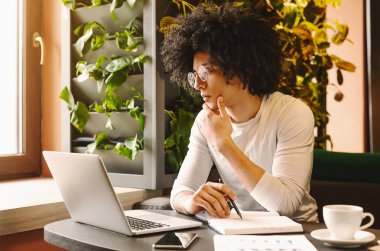 İşe konsantre oldun. Kendine güvenen genç adam kafede oturan dizüstü çalışan, boş alan