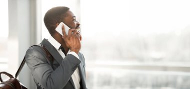 Seyahat eden iş adamı telefon görüşmesi yapıyor, havaalanına varıyor ve kalkışı bekliyor.