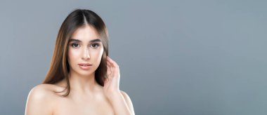 Uzun dalgalı saçlı, kendine güvenen bir ifadeyle poz veren bir kadın eşsiz tarzını sergiliyor..