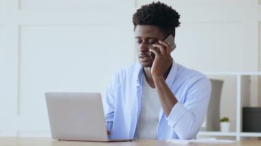 Yardım hattını arayın. Genç Afro-Amerikalı adam operatörle telefonda konuşuyor, dizüstü bilgisayarla ilgili sorunları var.