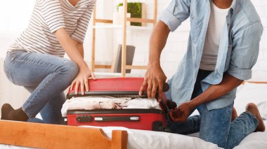 Bavul paketleme. Çift balayı için hazırlanıyor valiz, kapatmaya çalışırken