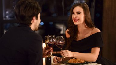 Restoranda romantik bir akşam yemeği yiyen tatlı bir çift. Mutlu aşıklar yıldönümü konseptini kutluyor.