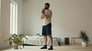 Milenyum adamı evde antrenman yapıyor, yatak odasında el egzersizi yapıyor.