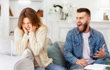 Oturma odasındaki kanepede oturan bir adam ve kadın..