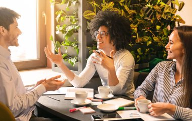 Kafe 'de etkileşim halinde olan genç bir takım, ilham verici siyahi adam, harika fikirlerini meslektaşlarına anlatıyor, boş alan.