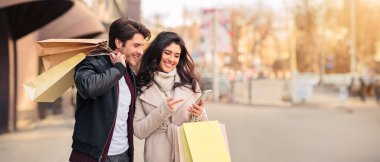 Taksionline sipariş edin. Modern butikler açık alışveriş sonra akıllı telefon kullanarak Çift