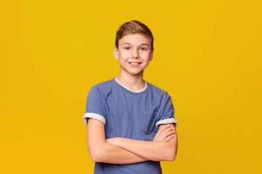 Turuncu stüdyo arka planda katlanmış elleri ile poz emin genç