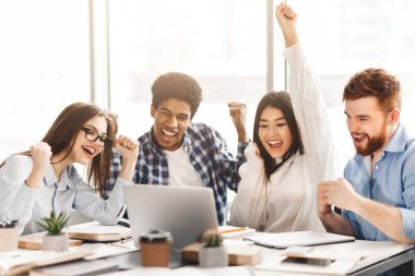 Evet, sınavlar geçti. Mutluluklarını ifade eden duygusal öğrenciler, kütüphanede dizüstü bilgisayara bakıyorlar.