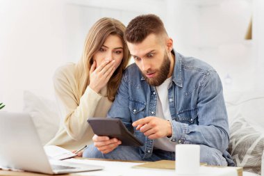 Bir erkek ve bir kadın birlikte bir tablet cihazında bilgi görmekle meşguller..