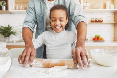 Afro amerikan adam ve küçük kız birlikte ev yapımı pasta pişirme