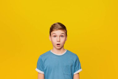 Turuncu studio arka plan üzerinde hayrete şok küçük çocuk portresi