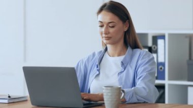 Evden uzakta çalışan neşeli bir kadın laptopta ortaklarıyla sohbet ediyor.