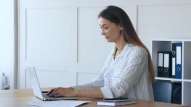 Mutlu iş kadını iş yerinde dans ediyor, laptoptan harika haberler okuyor.