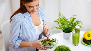 Sağlıklı Akşam Yemeği. Evde Mutfak sebze salatası yiyen kadın, ürün