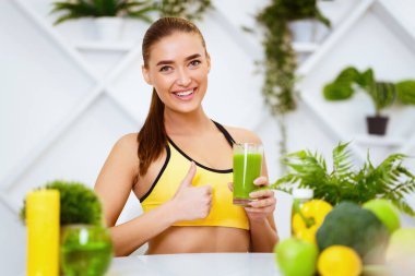 Fit Kız Sağlıklı Meyve Smoothie 'yi Öneriyor, Mutfakta Başparmağını Gösteriyor