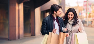 Alışveriş poşetlerine bakan genç alışverişkolikler, butiklerde alışveriş yaptıktan sonra birlikte vakit geçiriyorlar