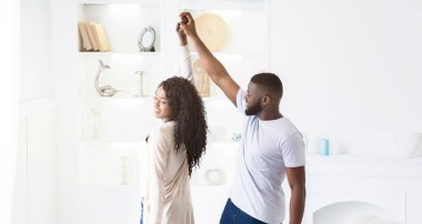 Beyaz bir odada bir çift dans eder, adam gülümseyerek kadına yol gösterir..