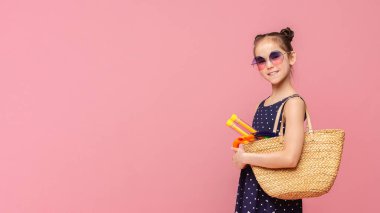 Sahile doğru. Küçük kız dalgıç çantası, pembe stüdyo arka planda dalış maskesi ile yüzmeye gidiyor