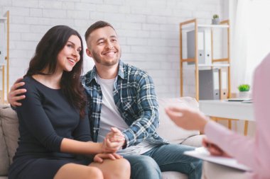 Bir çift danışmanlık seansı sırasında bir ofiste kanepede birlikte oturur. Adamın kolu kadının boynuna dolanmış ve ikisi de kamera dışında bir şekle bakıyor.
