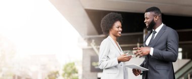 Yakışıklı siyah adam onun kadın meslektaşı komik şaka anlatıyor ve dijital tablet tutarak