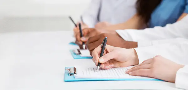 Stock image Medical seminar. Doctors writing notes at conference in hospital, closeup