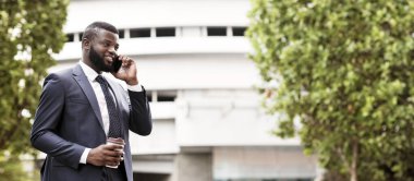 Her zaman temas halinde. Şehirde Kahve Molası Sırasında Cep Telefonuyla Konuşan Afro-Amerikan İşadamı. Boş alan