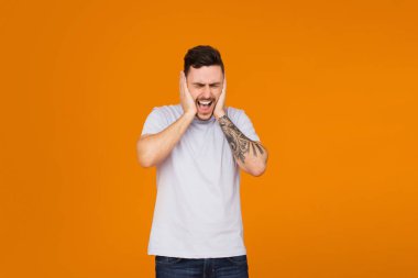 Turuncu arka plan üzerinde ağzını, kulaklarını ve gözlerini kaplayan komik adamlar