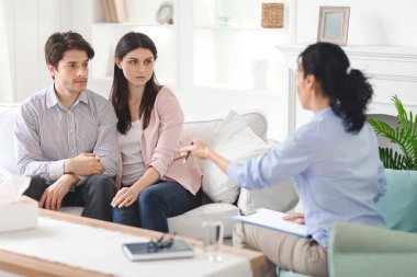 Genç bir çift, sakin bir ofiste iletişimi ve anlayışı geliştirmeyi amaçlayan destekleyici bir kadın terapistle ilişkilerindeki zorlukları tartışıyor..