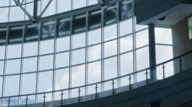İş binasının büyük cam penceresinden bulutlu gökyüzünün zamanlaması