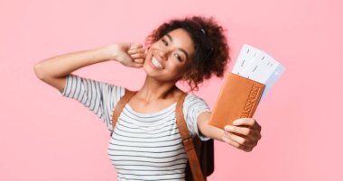 Mutlu kadın pasaport ve bilet pembe bir arka plan üzerinde closeup gösterilen