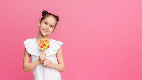 stock image Sweet Summer Time. Happy little girl enjoying candy, smiling with big colorful lollipop, pink studio background