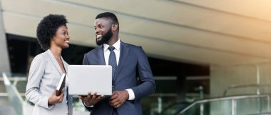 Modern kentsel ortamda dizüstü bilgisayar kullanarak iş adamı ve kadın, boş alan