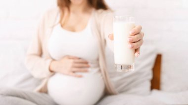 Emzirme ve emzirme kavramı. Kamerada taze süt ve kavramsal fotoğraf sunan hamile bir kadın.