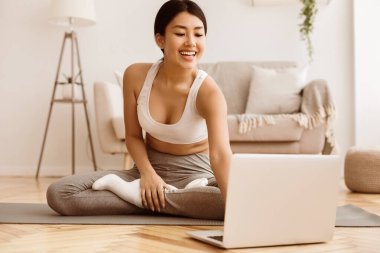 Online Eğitim. Kız Yoga Egzersizleri yapıyor ve Laptop Öğretici Ders izliyor